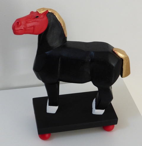 Petit cheval noir et or à tête rouge et sabots blancs avec boules rouges